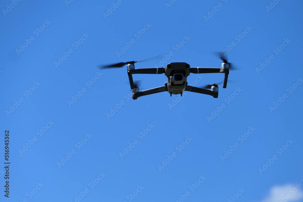 Gray quadcopter in flight. Photo-video aerial photography. Gray quadcopter in flight. Photo-video aerial photography.