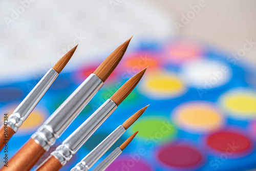 Background of various brushes on watercolor palette.