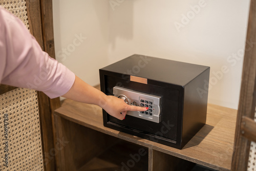 Woman opening safe box on light background