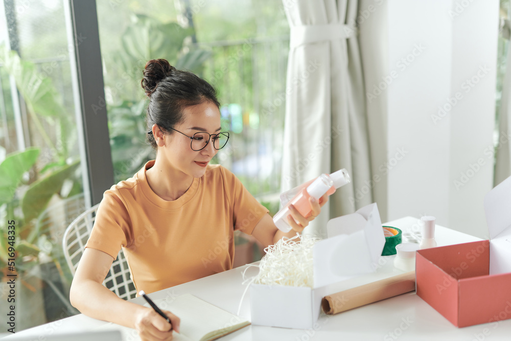 young asian online business store owner check his product at her office workshop. young asian online business store owner check his product at her office workshop.