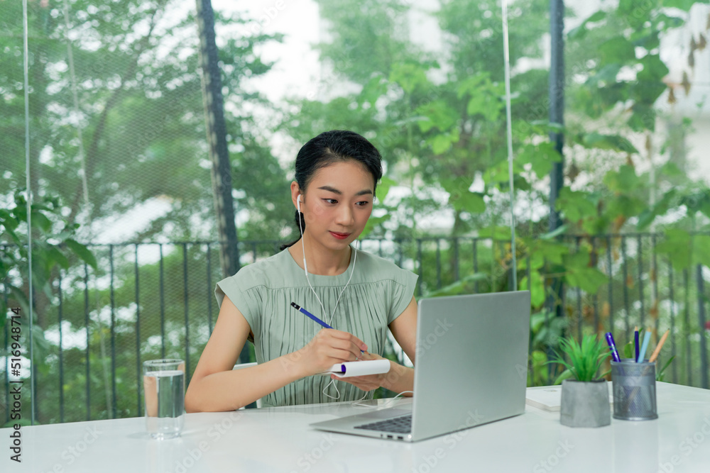 attractive cheerful young business woman write notebook look computer sit desk chief leader indoors in office attractive cheerful young business woman write notebook look computer sit desk chief leader indoors in office