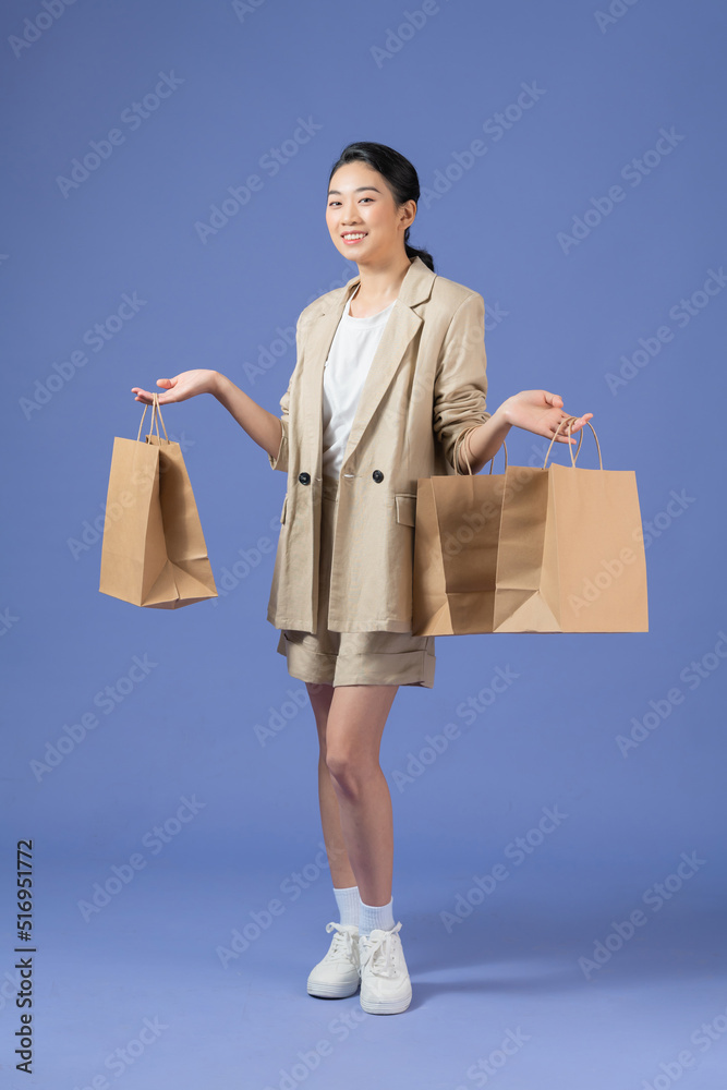 Happy young woman with shopping bags on purple background Happy young woman with shopping bags on purple background