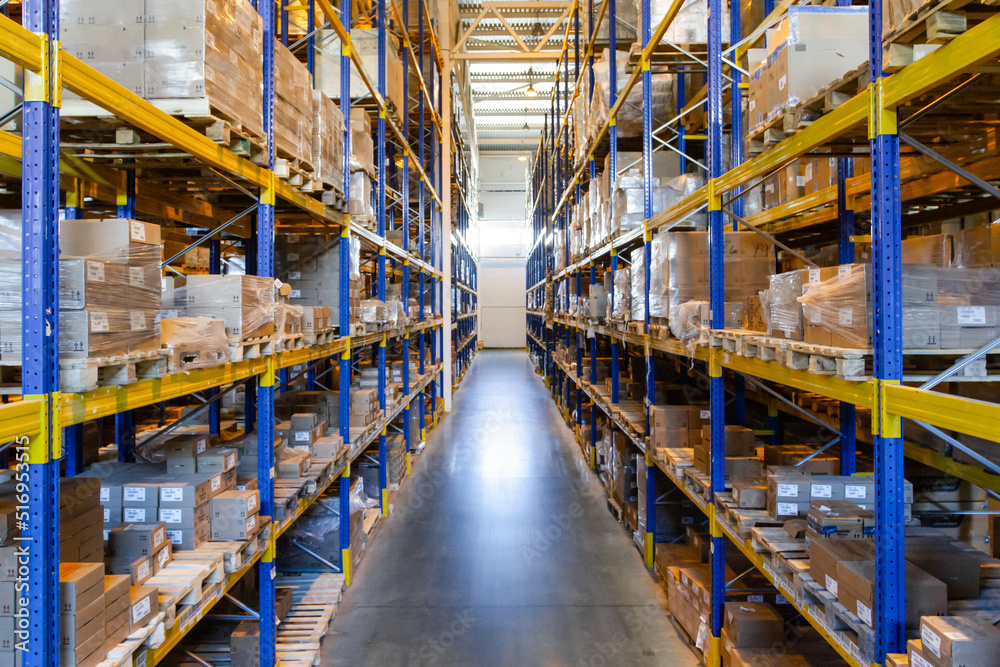 Interior of a modern warehouse storage with rows and goods boxes on high shelves Interior of a modern warehouse storage with rows and goods boxes on high shelves