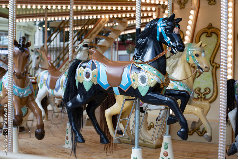 Black plastic horse toy close-up, children carousel amusement park