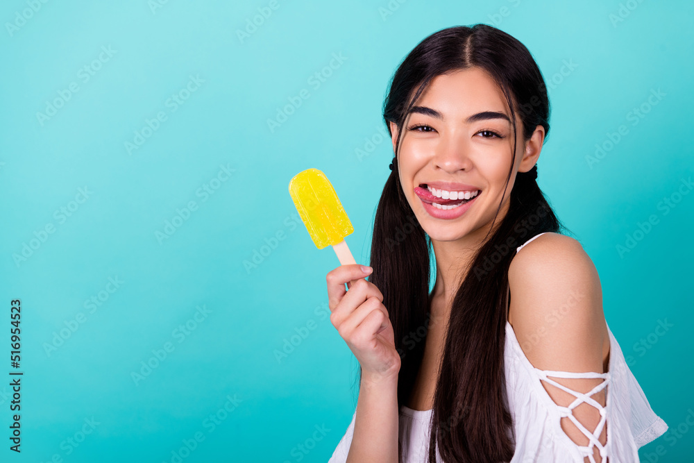 Photo of pretty adorable lady protrude tongue hold delicious juicy popsicle copyspace isolated cyan color background Photo of pretty adorable lady protrude tongue hold delicious juicy popsicle copyspace isolated cyan color background