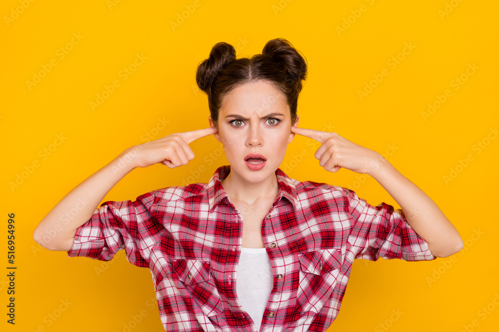 Portrait of impressed unsatisfied lady fingers close ears look camera isolated on yellow color background Portrait of impressed unsatisfied lady fingers close ears look camera isolated on yellow color background