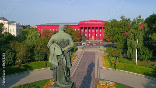 Aerial view back view statue of the writer Taras Grigorovich Shevchenko in park on a sunny spring day. Drone shot red building facade Kyiv National University of Taras Shevchenko. Capital of Ukraine photo