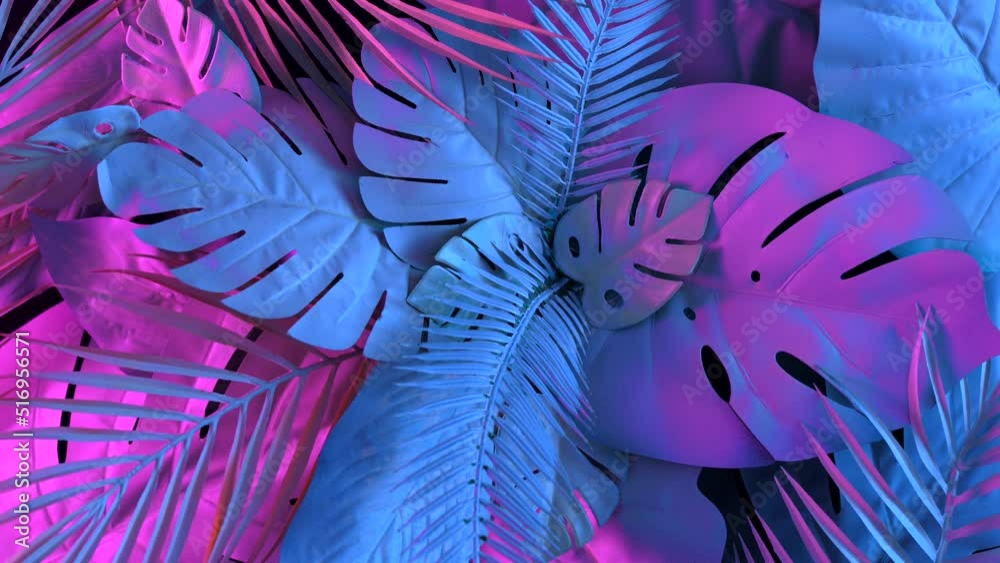 Creative flat lay with leaves in vibrant gradient holographic neon colors. Minimal jungle background rotation around its axis. Creative summer concept.