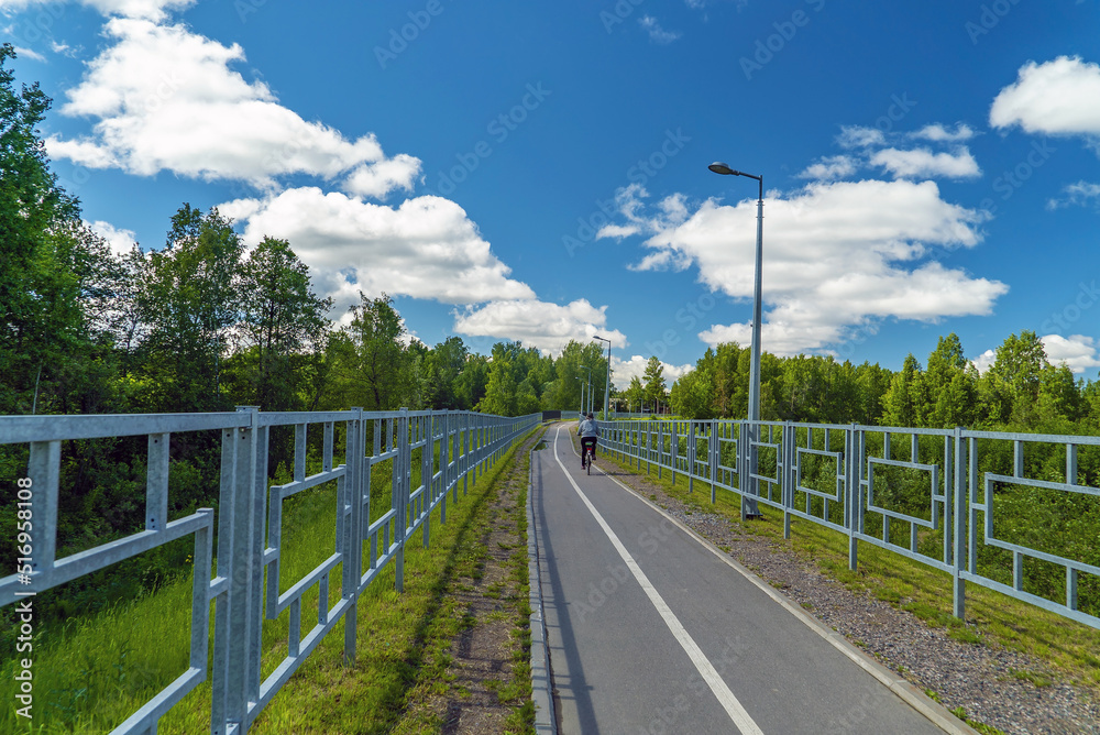 A safe bike and pedestrian path fenced on both sides with a fence.