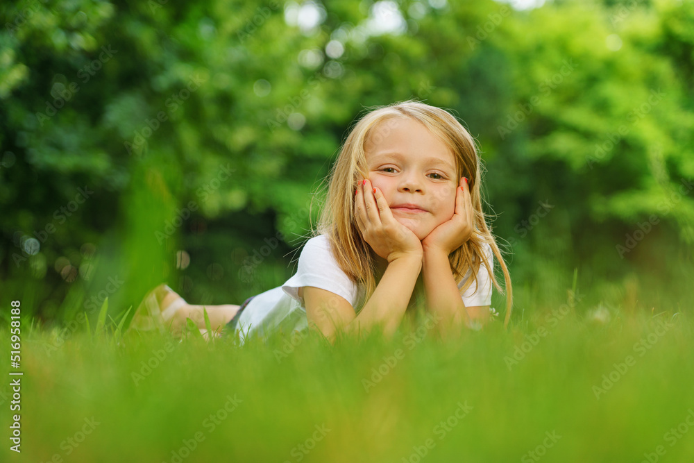 Portrait of a little girl who poses for a photo in the garden in summer. Portrait of a little girl who poses for a photo in the garden in summer.