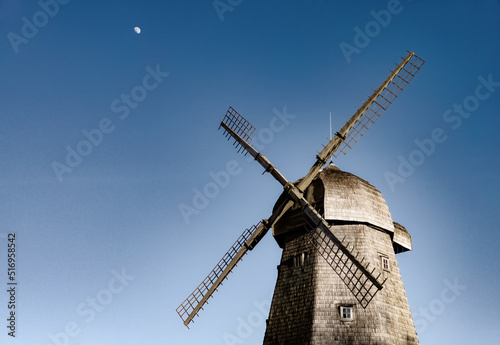 Windmill with blue sky with moon in background.