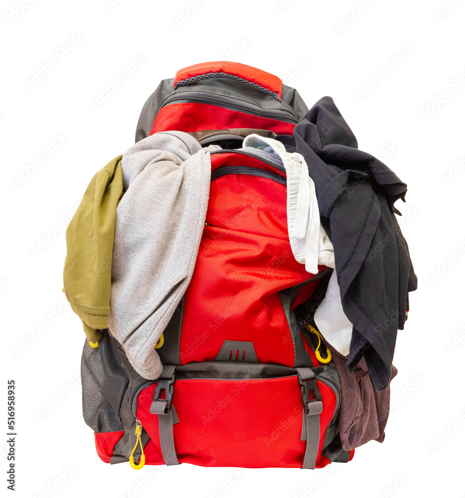 Badly folded clothes. Clothes sticking out of a backpack. Overflowing  tourist backpack on a white background. Stock Photo