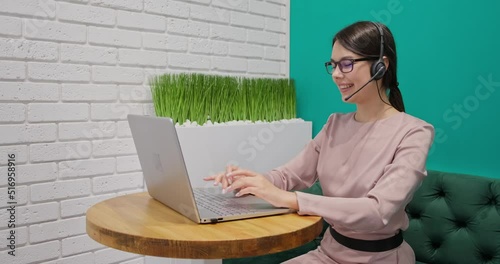 Happy female, office worker wears headset conference video calling 