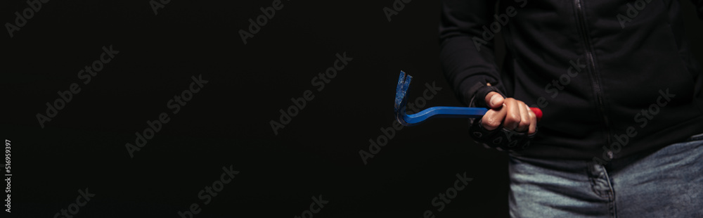 Cropped view of african american hooligan holding crowbar tool isolated on black, banner