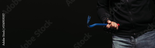 Cropped view of african american hooligan holding crowbar tool isolated on black, banner