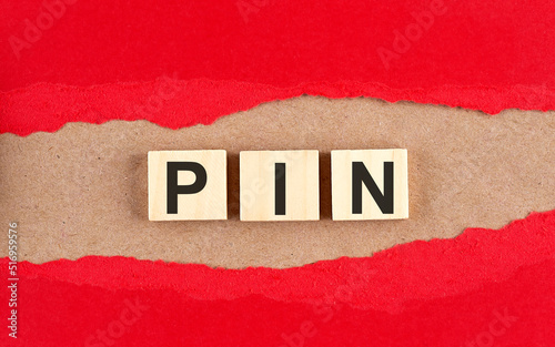 PIN word on wooden cubes on red torn paper , financial concept background