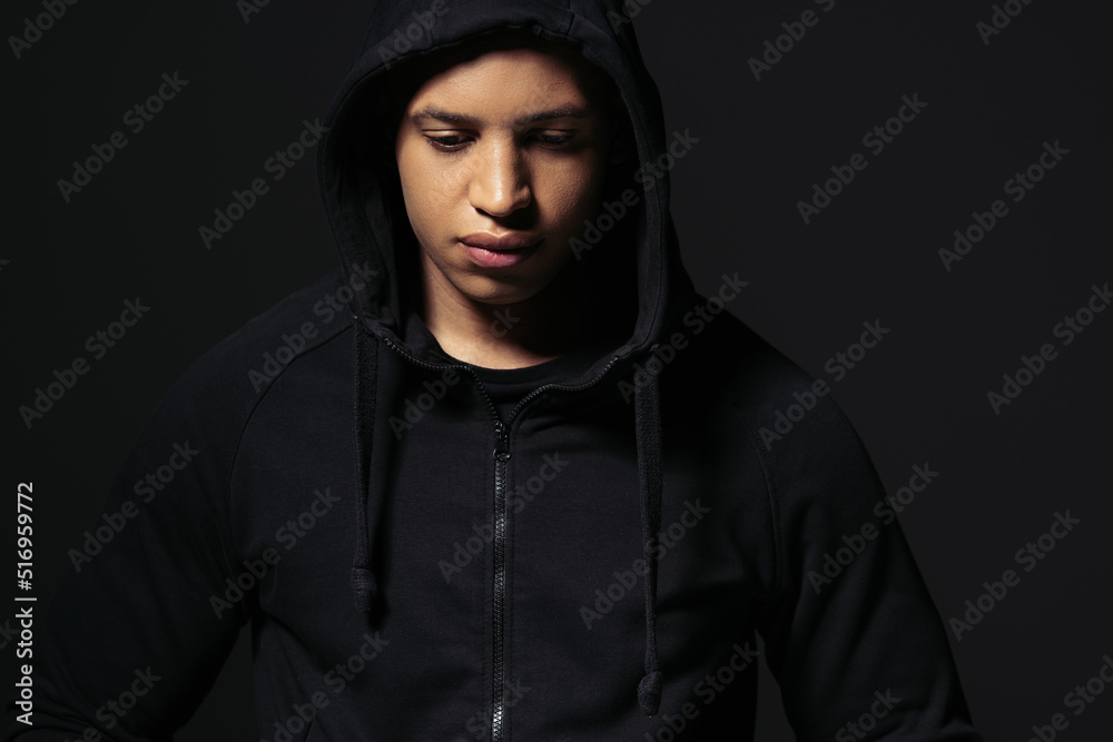African american hooligan in hoodie standing isolated on black