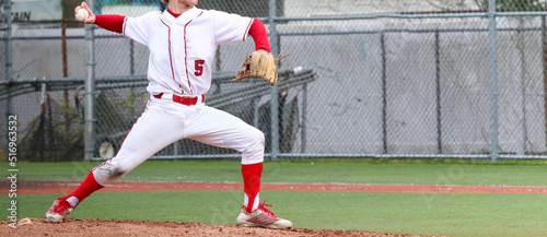 High school baseball pitcher in full wind up pitching during a game photo