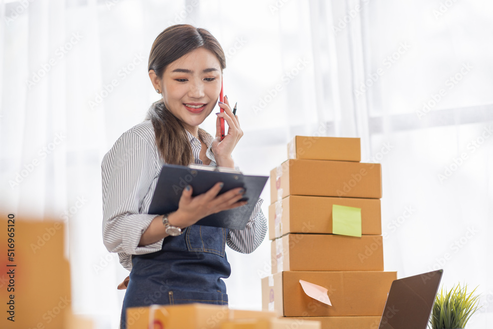 Portrait of young Asian woman working SME with a box at home the workplace.start-up small business owner, small business entrepreneur SME or freelance business online and delivery concept. Portrait of young Asian woman working SME with a box at home the workplace.start-up small business owner, small business entrepreneur SME or freelance business online and delivery concept.