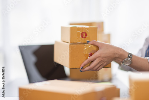 Portrait of young Asian woman working SME with a box at home the workplace.start-up small business owner, small business entrepreneur SME or freelance business online and delivery concept. © David