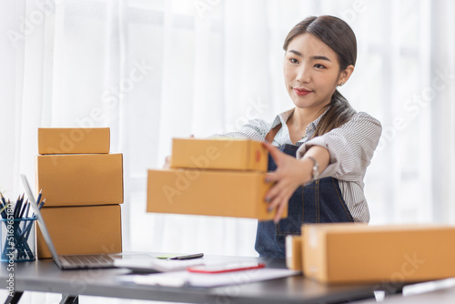 Portrait of young Asian woman working SME with a box at home the workplace.start-up small business owner, small business entrepreneur SME or freelance business online and delivery concept.