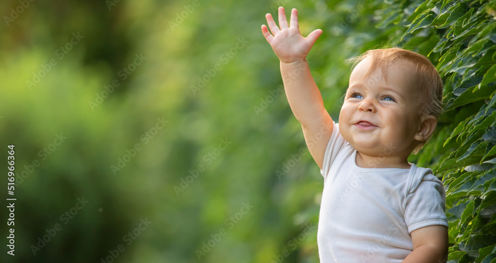 A cheerful and happy little boy is sitting on a green lawn. A cheerful and happy little boy is sitting on a green lawn.