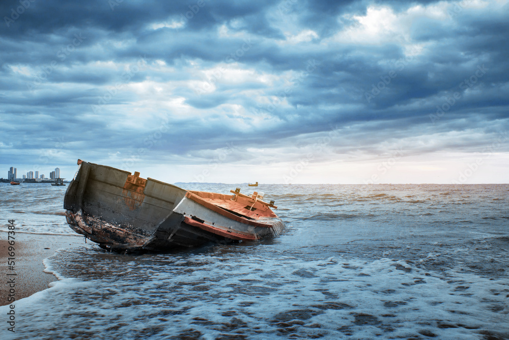 Abandoned ship on the seashore and the lines of the cloudy dark sky Abandoned ship on the seashore and the lines of the cloudy dark sky