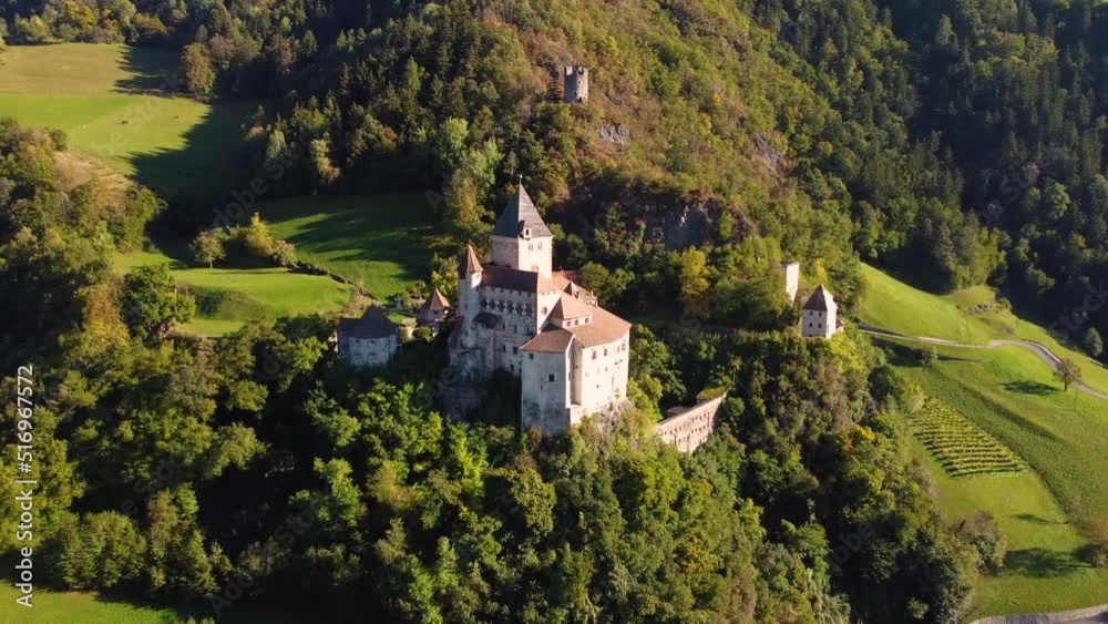 Val Isarco, Italy - 4K Flying away from Trostburg Castle (Castel Trostburg), a XII century fortress at the Italian Dolomites on a sunny autumn day with autumn foliage and blue sky with clouds Val Isarco, Italy - 4K Flying away from Trostburg Castle (Castel Trostburg), a XII century fortress at the Italian Dolomites on a sunny autumn day with autumn foliage and blue sky with clouds