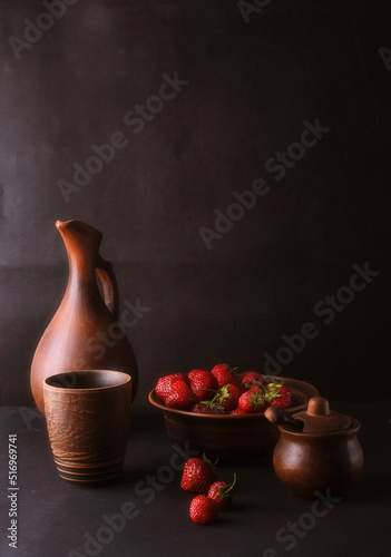 Still life with strawberries and cornflowers on a black background