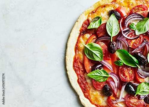 Homemade thin crust pizza with mozzarella, cherry tomato, pepper, onion and Kalamata olives