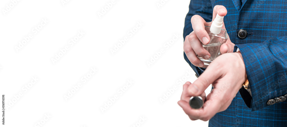Fototapeta premium Professional man in business suit cropped view spray perfume to wrist isolated on white, testing. Horizontal poster design. Web banner header, copy space.