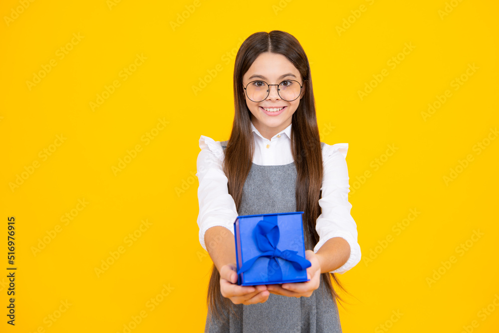 Teenager child girl holding present box isolated over yellow studio background. Present, greeting and gifting concept. Birthday holiday concept. Teenager child girl holding present box isolated over yellow studio background. Present, greeting and gifting concept. Birthday holiday concept.