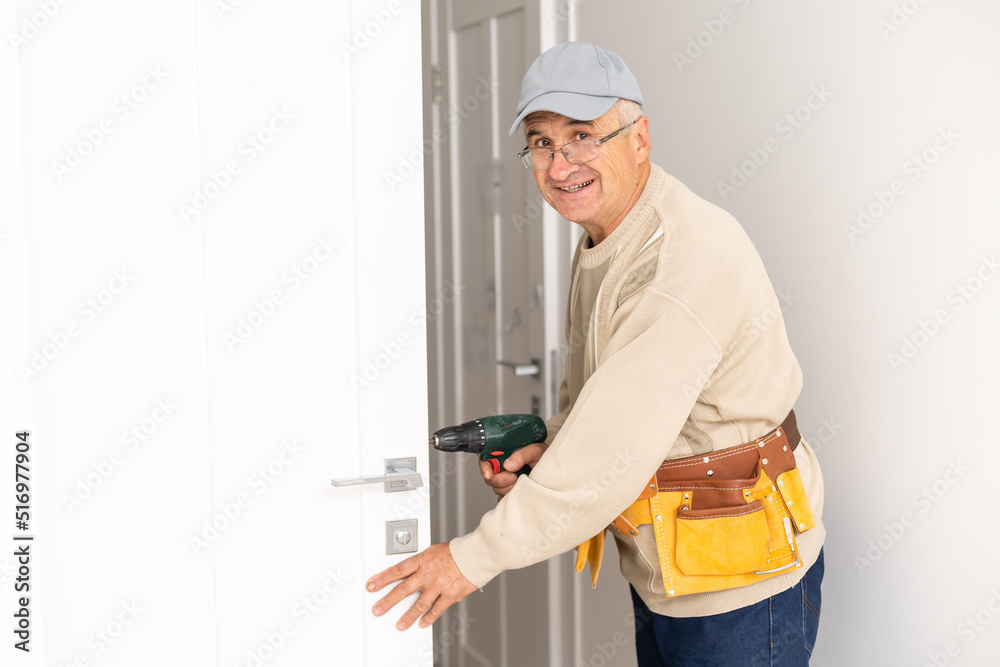 Installation of a lock on the entrance door Hand 's man with screwdriver Installs door knob. Installation of a lock on the entrance door Hand 's man with screwdriver Installs door knob.