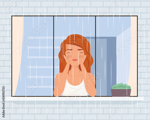 woman watching rain through the window