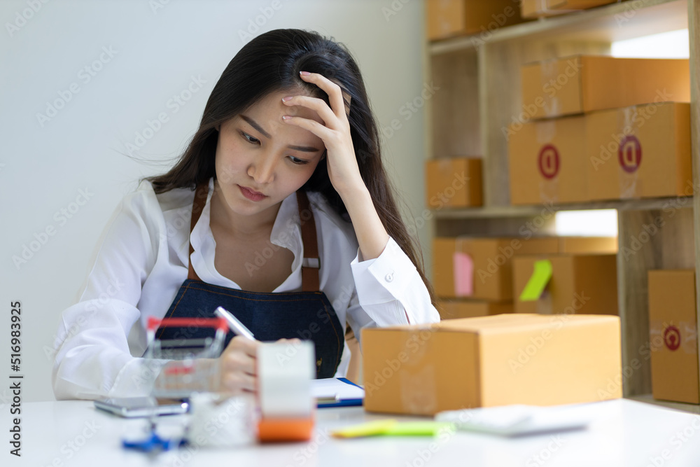 Small business owners are worry of the drop in orders. A young woman starting an online business works on her laptop and waits for orders. Small business owners are worry of the drop in orders. A young woman starting an online business works on her laptop and waits for orders.
