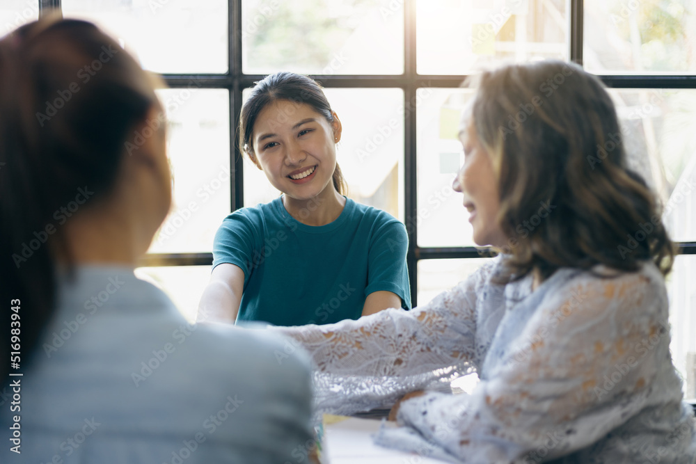 Group of young colleagues meeting with a senior female manager in the office to discuss their experience working on a company project. Group of young colleagues meeting with a senior female manager in the office to discuss their experience working on a company project.