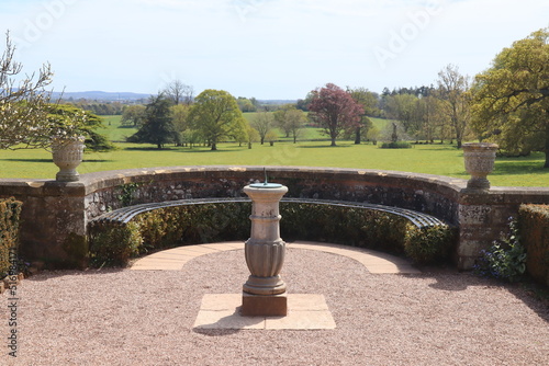 A sundial in the grounds of an English stately home looking towards the extensive estate