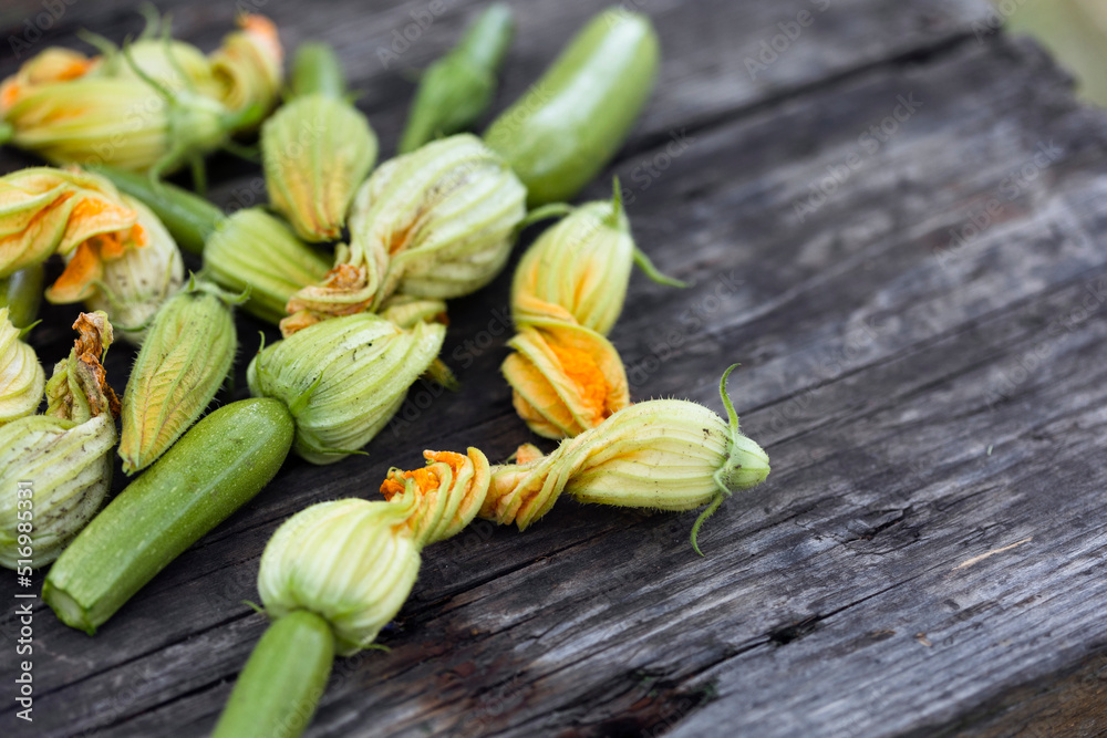 zucchini with flowers on a wooden background zucchini with flowers on a wooden background