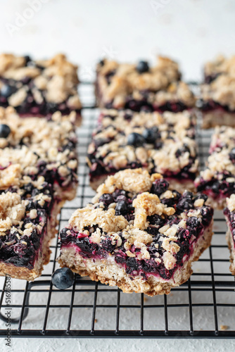 Homemade blueberry crumble bars on baking rack close up on white background, healthy snack for school