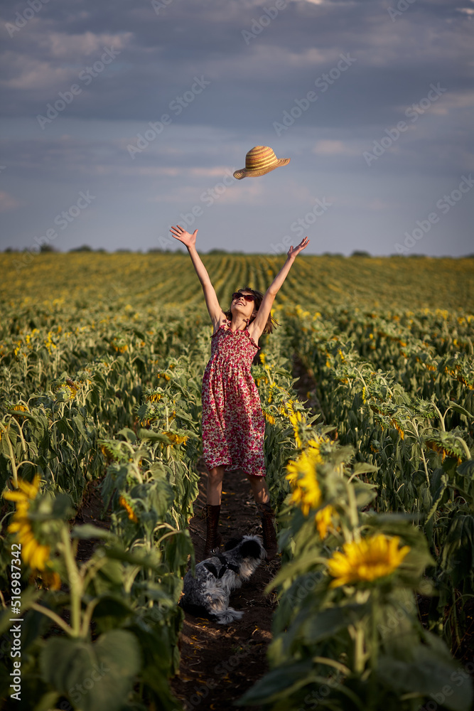 Fototapeta premium Cute girl in a sunflower field.