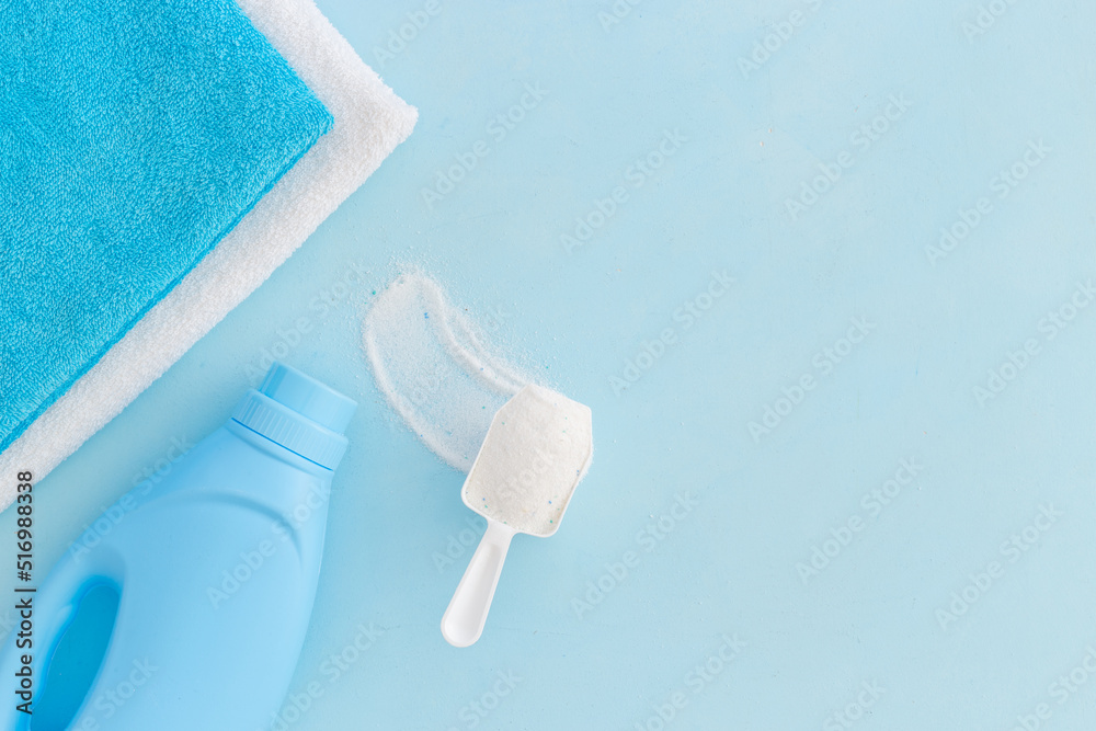 Fototapeta premium White washing powder with towels and a laundry conditioner bottle