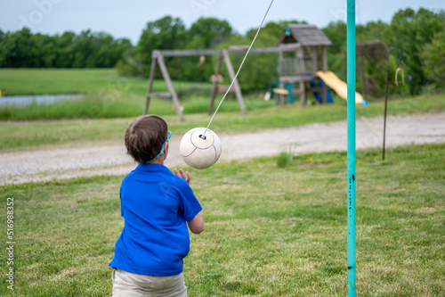 Tetherball being hit and roped in a game with a young boy. 