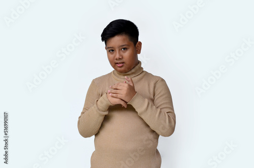 asian boy with expression holding hands on chest, isolated at white background © farzand01