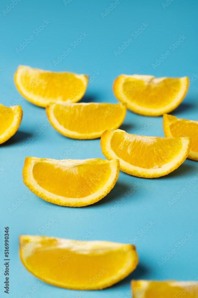 Close up view of cut orange pieces on blue background. Close up view of cut orange pieces on blue background.