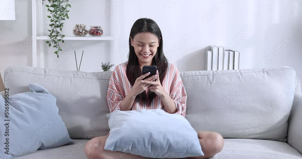 Happy young beautiful Asian woman playing smartphone at home. Happy young beautiful Asian woman playing smartphone at home.