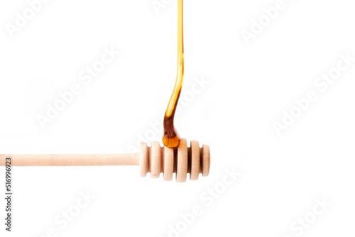 Tasty honey falling on a wooden dipper. Healthy food