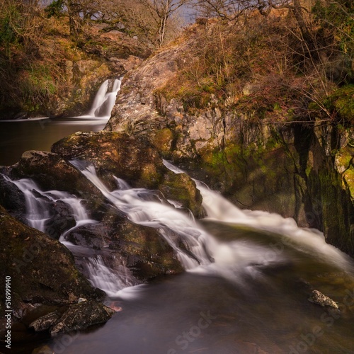 Long exposure shot of Beezley Falls surrounded by trees in Ingleton, United Kingdom photo