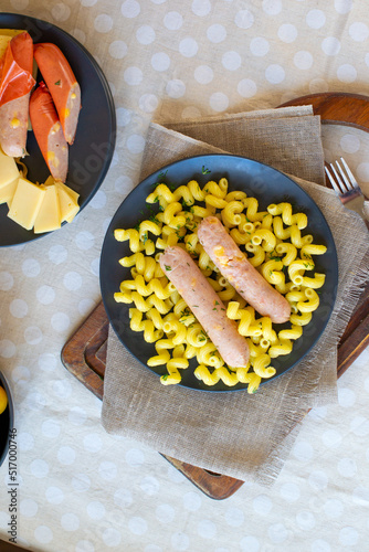 Boiled cheese sausages with cellentani garnish photo