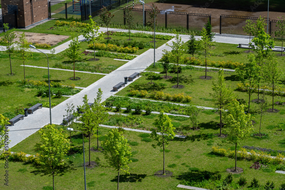 top view of green park with school football field, footpaths and trees at spring day