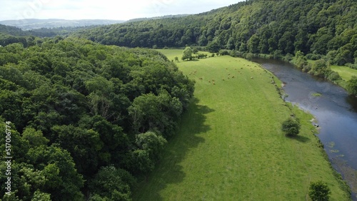 Aerial view of a river flowing through green land on a beautiful sunny day in Thomastown, Kilkenny